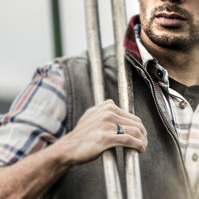 Man wearing a black silicone ring while working outdoors