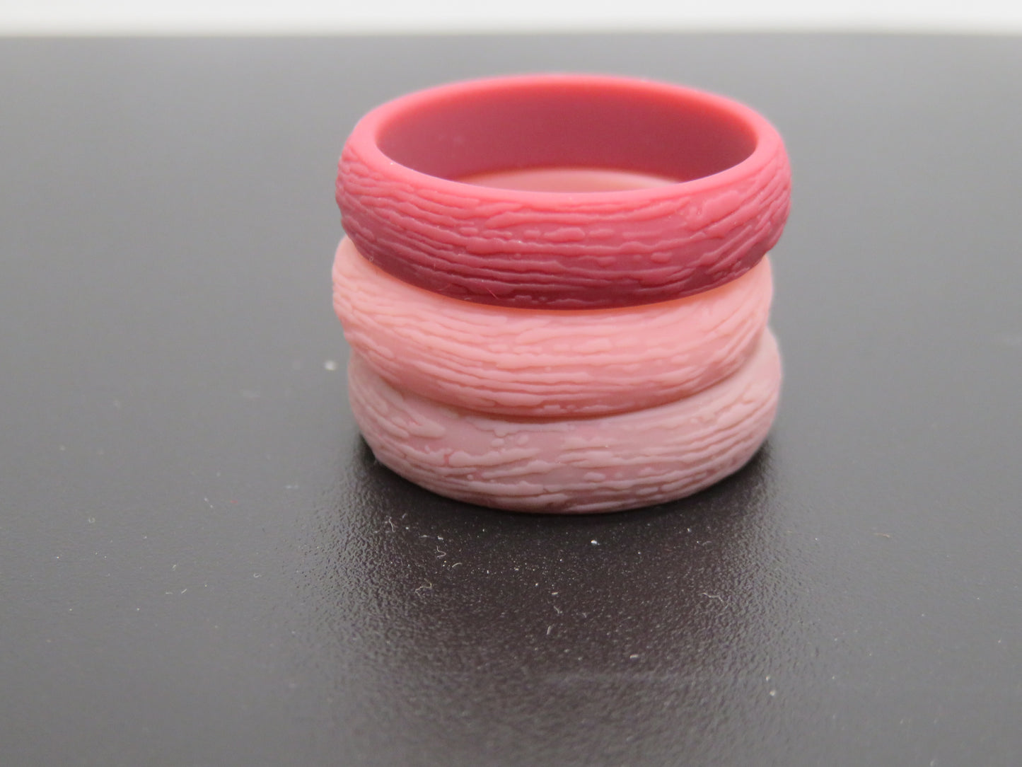 Woman's hand wearing colorful Dersa silicone rings