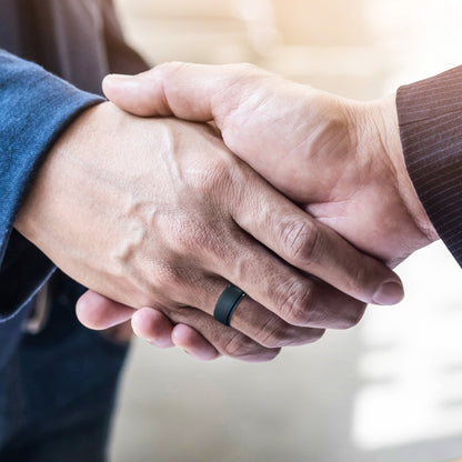 Professional handshake with silicone rings visible on finger